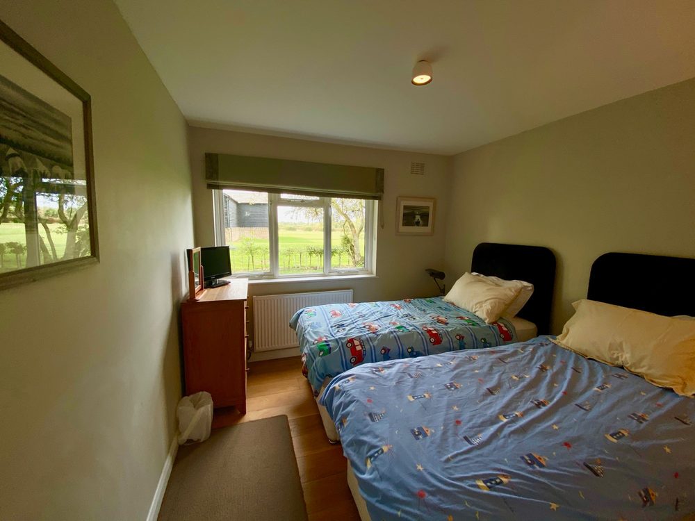 A twin bedroom, with a view of the barn
